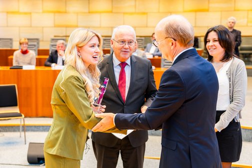 André Kuper schüttelt Delia Jung die Hand. Neben den beiden stehen Jury-Vorsitzender Wilfried Böhm und Laudatorin Anke Unger.