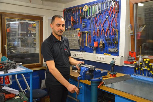 Ein vilmA-Preisträger an seinem Arbeitsplatz, einer Werkbank ausgestattet mit zahlreichen Werkzeugen.